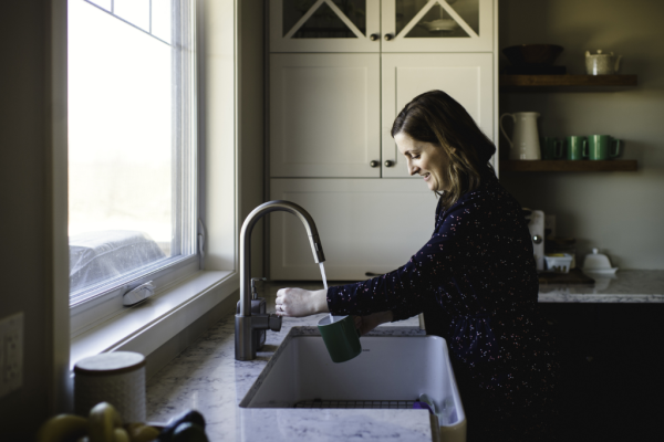 woman-filling-up-cup-at-kitchen-sink-2022-03-04-01-44-01-utc